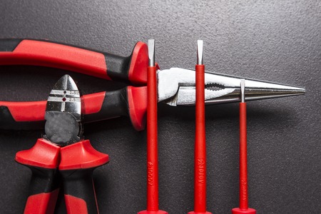 Electrician tools on black background. Screwdrivers, cutters and platypuses on black background