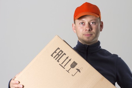 Free shipping concept. Courier delivery man with cardboard box in hands