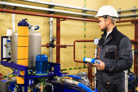 Maintenance boiler. Technician engineer adjusts plumbing systems. Industrial work.の写真素材