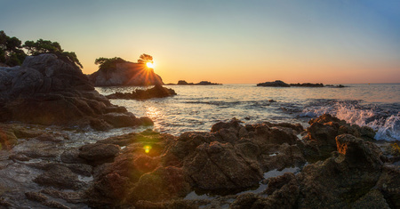 Scenic view on spanish sea coast in lloret de mar at sunrise. Costa Brava rocky beach in sun shineの写真素材