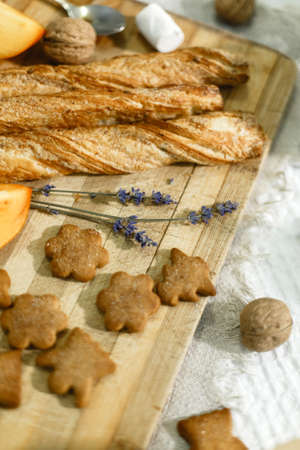 On the kitchen board are cookies, a bun, a flower, a spoon and a nut.の写真素材