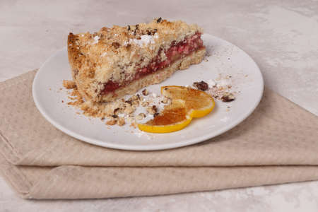 Shortcake and lemon in a white plate on a towel on a light background