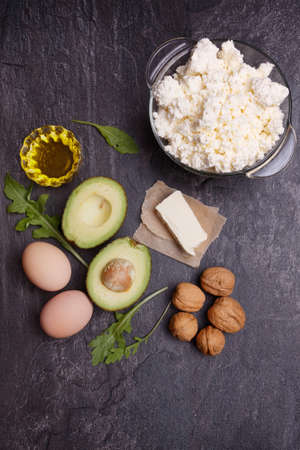A set of keto diet products. Meat, cottage cheese, walnuts, olive oil, chicken, avocados, greens and eggsの写真素材
