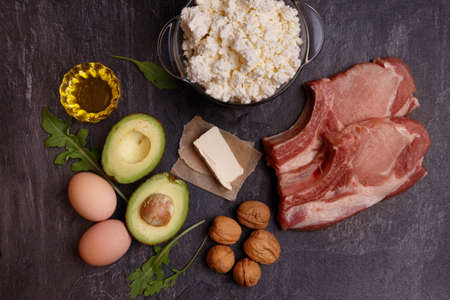 A set of keto diet products. Meat, cottage cheese, walnuts, olive oil, chicken, avocados, greens and eggsの写真素材