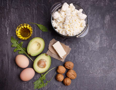 A set of keto diet products. Meat, cottage cheese, walnuts, olive oil, chicken, avocados, greens and eggsの写真素材