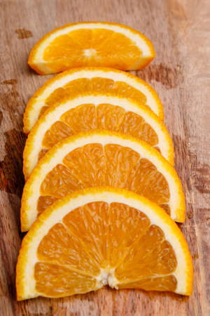 Orange slices lie on a kitchen wooden board. Close-upの写真素材