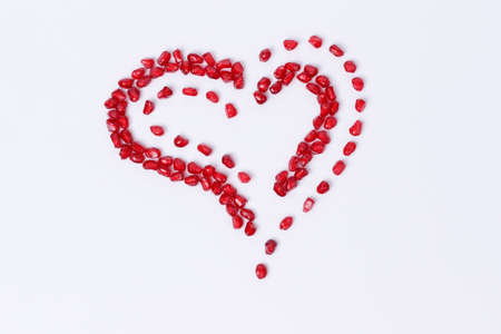Pomegranate isolated. Pomegranate seeds on white background. Heart shape.の写真素材