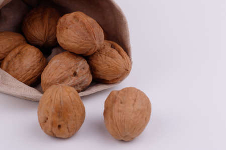 Whole walnuts in a pouch on a white background close-upの写真素材