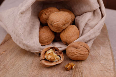 Closeup of walnuts in a bag and on a wooden board. Walnut Healthy Food