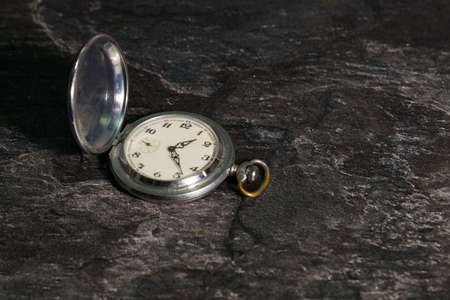 Old pocket metal watch on a dark background.の写真素材
