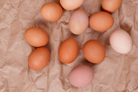 White and beige chicken eggs. Kraft paper background.