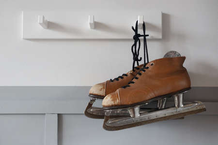 Old, brown skates on a hanger. Close-up