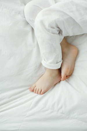 Feet of a sleeping baby on the background of bedding. Close-upの写真素材