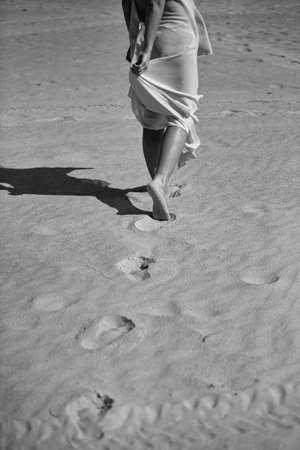 Traces of a woman leaving the sand. Black and white photographyの写真素材