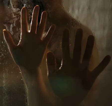 Hands of man and woman on wet glass in the shower. Close-up.