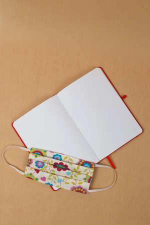 Notepad with blank white sheets and antivirus mask. Close-up. View from above.の写真素材