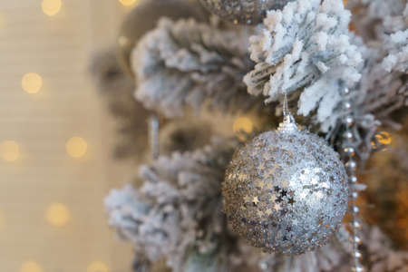 The Christmas tree is covered with hoarfrost and decorated with balls, beads and a garland.の写真素材