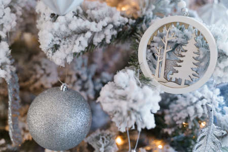 The Christmas tree is covered with hoarfrost and decorated with balls, beads, a garland and snowflakes.の写真素材