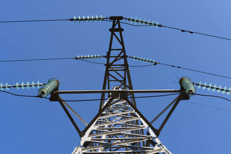 High voltage tower and power lines against a blue skyの写真素材