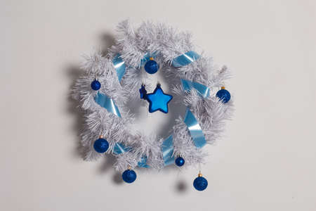 White Christmas wreath decorated with blue balls, stars and ribbon on a white background.の写真素材