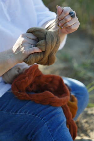 Woman hands sorting a ball of thread. Hands and threads close upの写真素材
