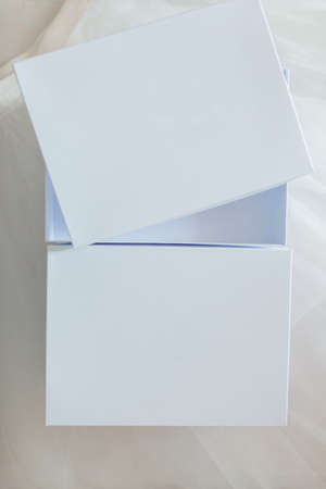 White gift boxes on a fabric background. One is openの写真素材