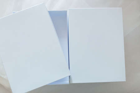 White gift boxes on a fabric background. One is openの写真素材