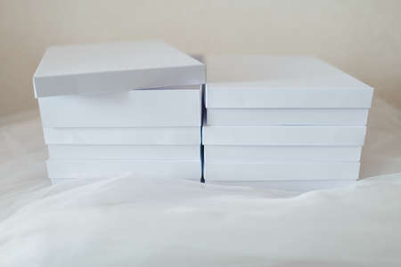 White gift boxes on a fabric background. One is openの写真素材
