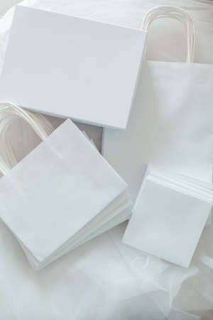 White gift paper bags and boxes. on a fabric background. View from aboveの写真素材