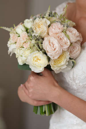 A wedding bouquet in the hands of the bride is pressed to her chest. Close-upの写真素材