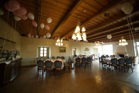 Festive interior of the room, chairs, tables set by the kitchen utensils, balloonsの写真素材
