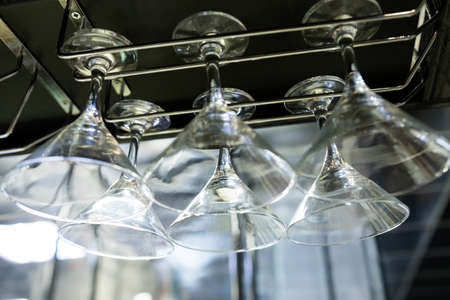 Martini glasses are hung on the bar counter.の写真素材