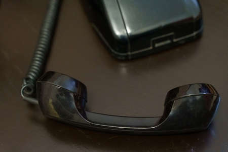 Handset and part of an antique black telephone desk