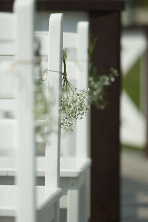 Decoration of the venue for the wedding event. Flowers suspended from chairsの写真素材