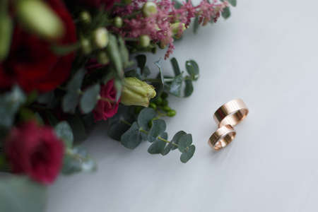 Wedding rings and bridal bouquet on a white backgroundの写真素材