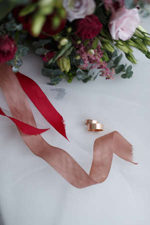 Wedding rings and bridal bouquet on a white backgroundの写真素材