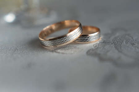 Macro: wedding rings made of white and yellow metal. The first ring is out of focus, the sharpness is on the second ring. Blurred backgroundの写真素材