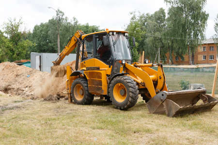 Excavator digs a trench. Side view. Close-upの写真素材
