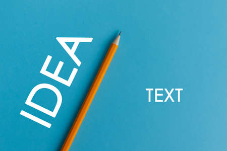 An interactive photo composition of an orange pencil and space for creative thinking (text) is used for presentation in the field of education, business or creativity. Lighting on a pencil in the studio. Blue backgroundの写真素材