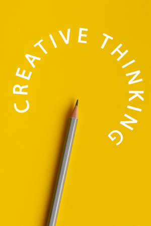 An interactive photo composition of gray pencil and space for creative thinking (text) is used for presentation in the field of education, business or creativity. Lighting on a pencil in the studio. Yellow backgroundの写真素材