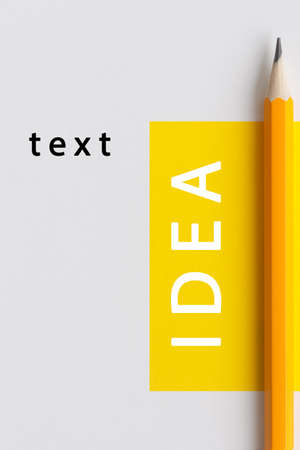 An interactive photo composition of an orange pencil and space for creative thinking (text) is used for presentation in the field of education, business or creativity. Lighting on a pencil in the studio. Yellow white backgroundの写真素材