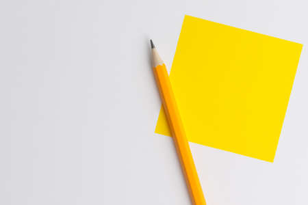 An interactive photo composition of an orange pencil and space for creative thinking (text) is used for presentation in the field of education, business or creativity. Lighting on a pencil in the studio. Yellow white backgroundの写真素材