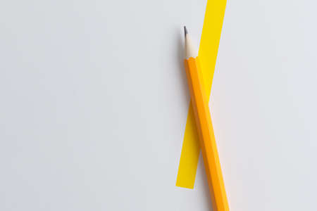 An interactive photo composition of an orange pencil and space for creative thinking (text) is used for presentation in the field of education, business or creativity. Lighting on a pencil in the studio. Yellow white backgroundの写真素材