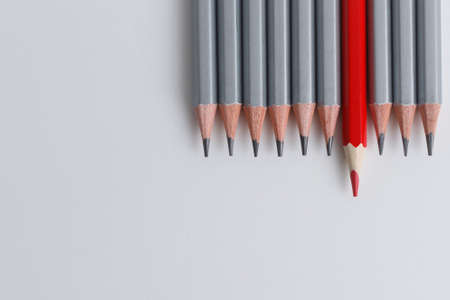 red pencil and gray pencils on a white paper background. Leader concept, different, uniqueの写真素材