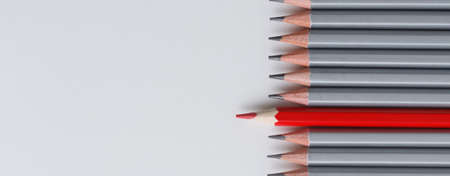 red pencil and gray pencils on a white paper background. Leader concept, different, uniqueの写真素材