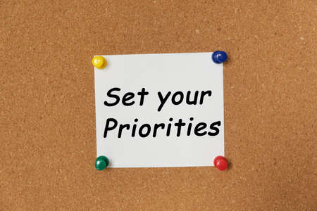 Text Set your Priorities written on a sticker pinned on a cork boardの写真素材