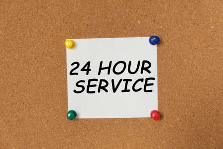 Text 24 HOUR SERVICE written on a sticker pinned on a cork boardの写真素材