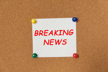 Text BREAKING NEWS written on a sticker pinned on a cork boardの写真素材