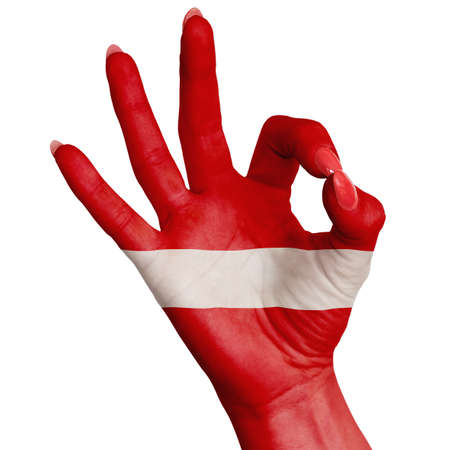 The national flag of Latvia is painted on a female hand showing the OK sign. Image on a white backgroundの写真素材