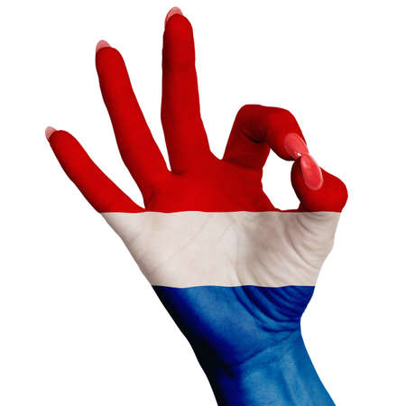The national flag of the Netherlands is painted on a female hand showing the sign OK. Image on a white backgroundの写真素材